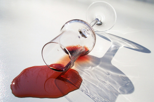 wine glass spilling wine on floor